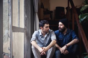 Couple of young men talking on the stairs of an office